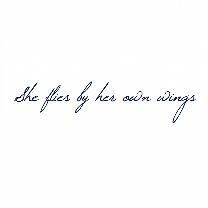 Temporary tattoo reading “she flies by her own wings” in fine-line script