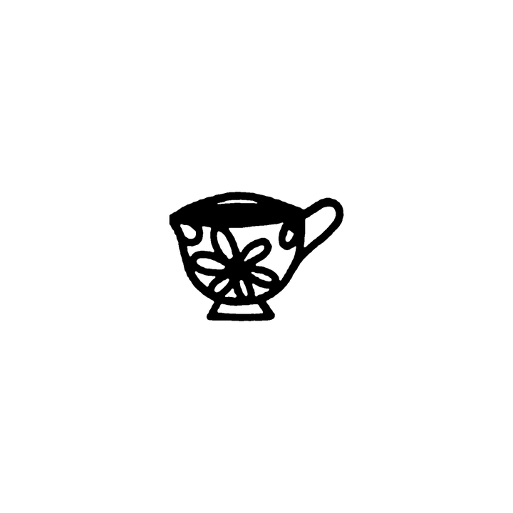A handled teacup on a short foot is decorated with a large flower and leaves, with a slim highlight along the rim.